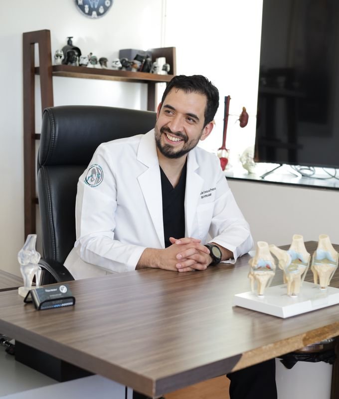 Dr. Eliseo Córdova explicando con modelos anatómicos en su consultorio
